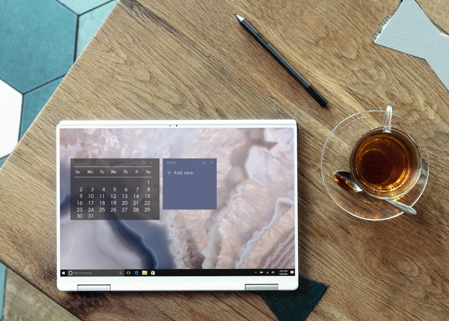 Laptop and tea on a wooden desk workspace.