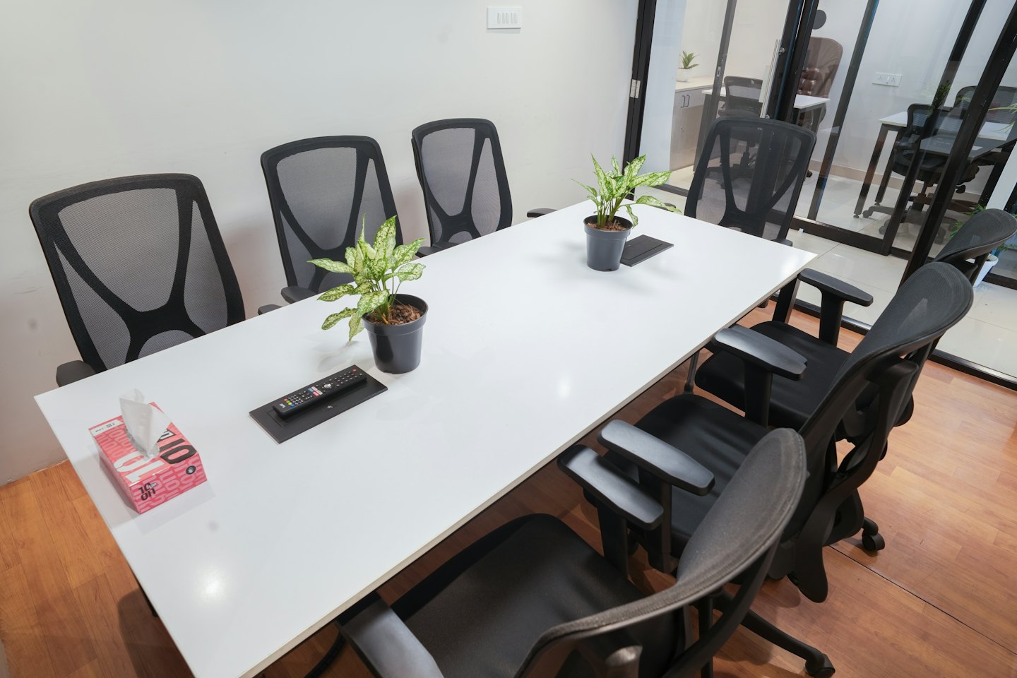 Conference table with chairs and plants in an office.
